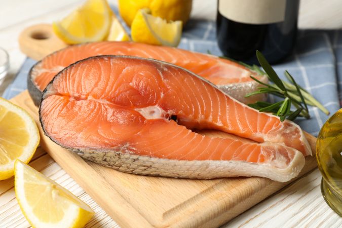 Composition with salmon meat and spices on wooden background, close up