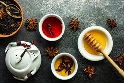 Tea pot with cups of tea and honey