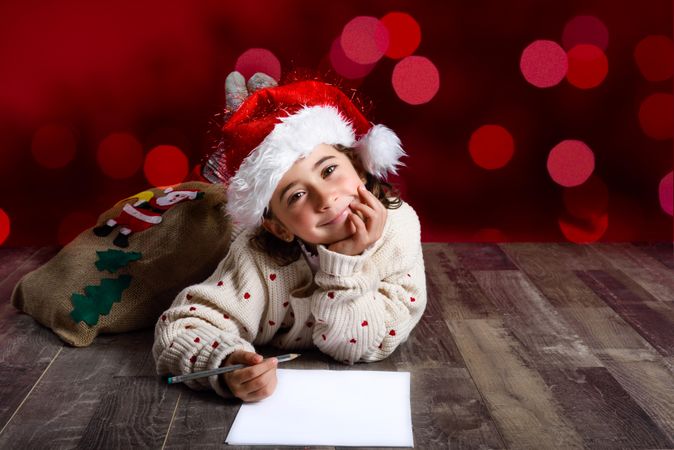 Female child thinking about writing a letter to Santa at Christmas time