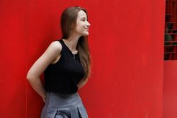 Woman standing with red background