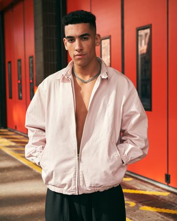 Stylish young man in open jacket and chain