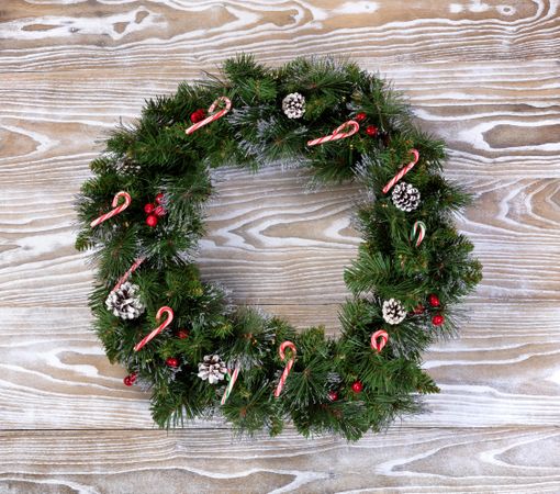 Christmas wreath with lights and candy canes on wood