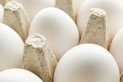 chicken eggs in carton box as background, closeup