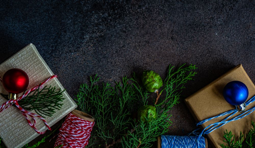 Christmas holiday concept with top view of gifts, baubles and branch