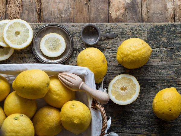 Lemons and reamer placed on wooden board