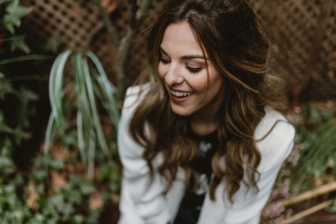 Woman sitting on planter in garden