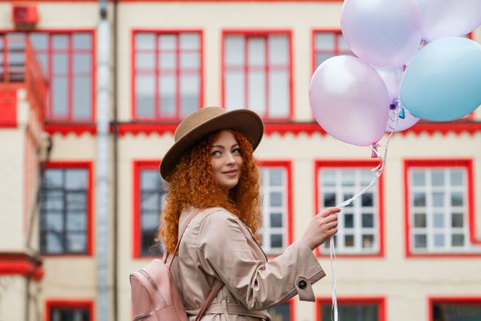 Woman walking in streets with balloons