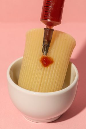 Stuffed pasta with red sauce in syringe