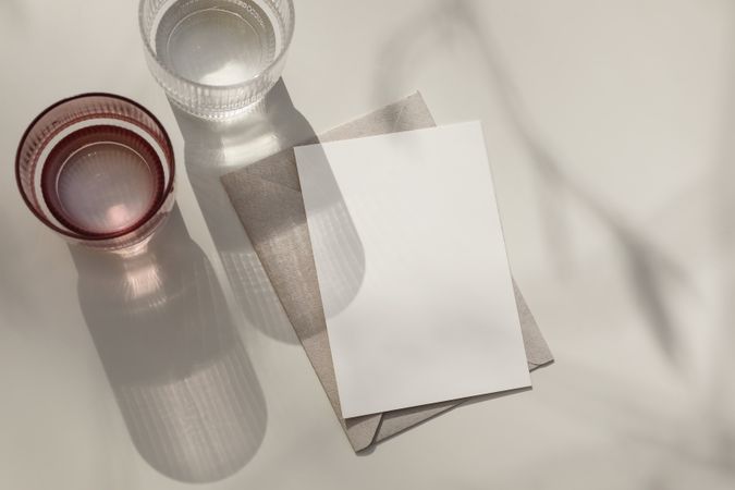 Two glasses of sparkling crystal water on beige background
