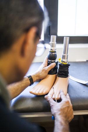 man fixing a prosthesis in a workshop