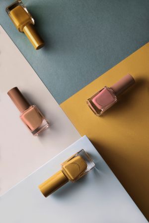 Multi-colored nail polish on pastel colors geometric pattern background