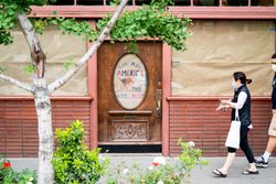 People walking on sidewalk in front of closed business