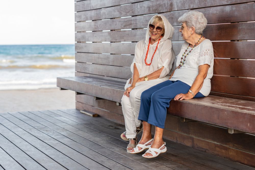 Older female friends talking on bench