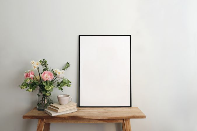 Blank picture frame mockup on table with pink flowers