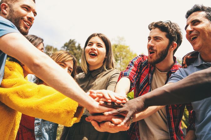 Group of friends with hands together in a show of unity and teamwork