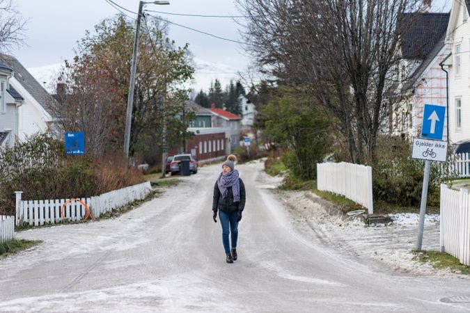 Female tourist in warm wear exploring suburbs of city