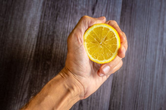 Crop hand with fresh lemon