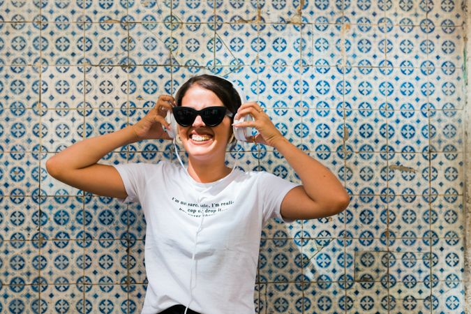 Cheerful casual woman in sunglasses standing on city street