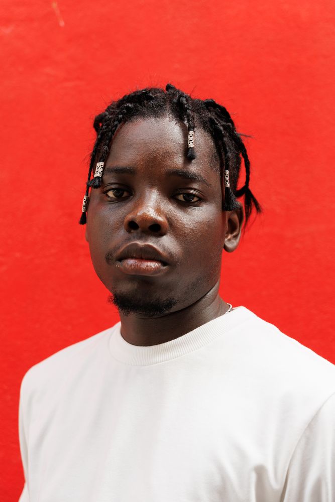 Black man with unique hair, Standing at red background