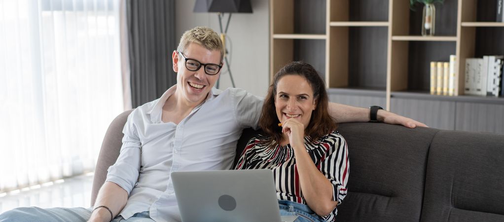 Couple talking and looking on laptop together in the living room