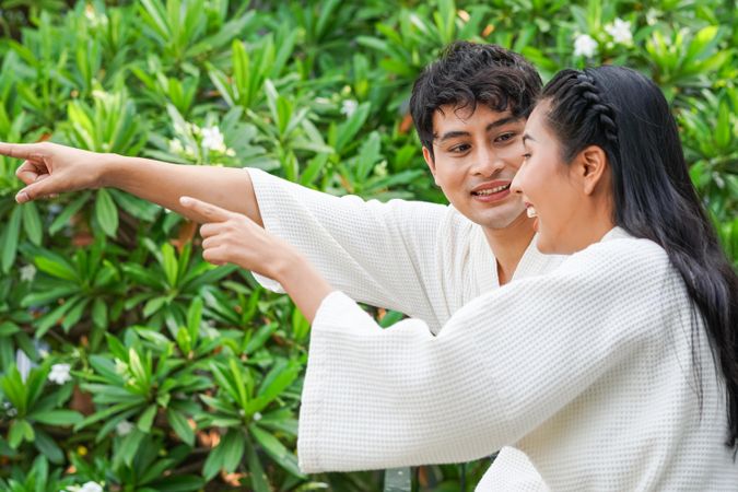 Asian couple pointing and smiling at something