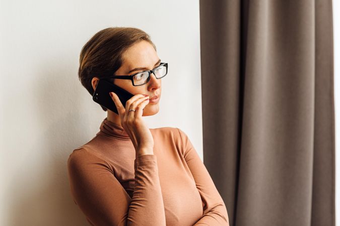 Female with eyeglasses looking away while using cell phone