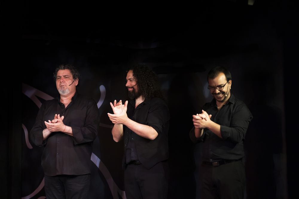 Hispanic men clapping hands during performance