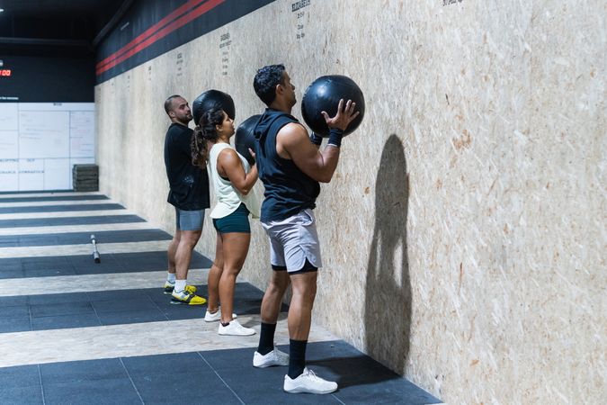 Hispanic sportspeople training with medical balls