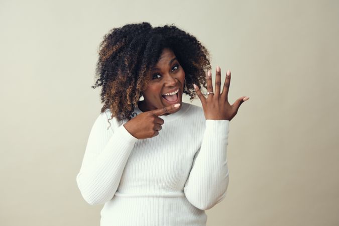 Portrait of excited Black woman showing off engagement ring