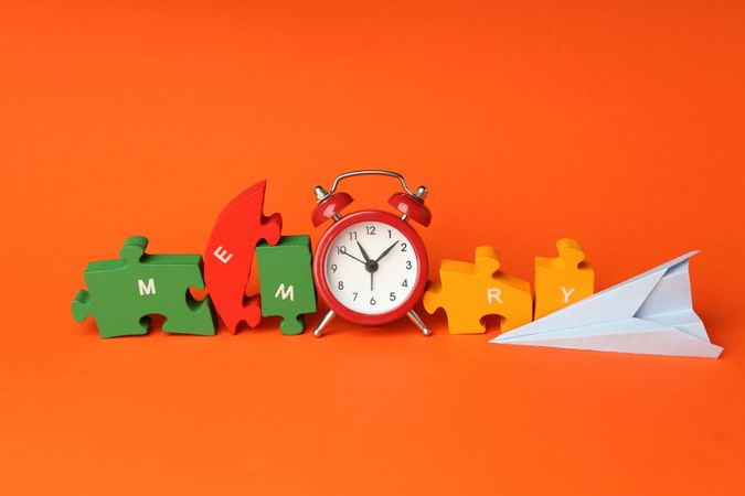 Puzzle pieces spelling “memory” in orange room with alarm clock