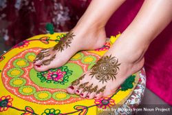 Indian bride's henna tattooed feet on cushion 0Kx1z5