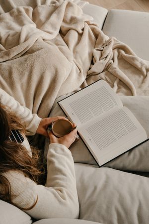 Person reading a book on the bed