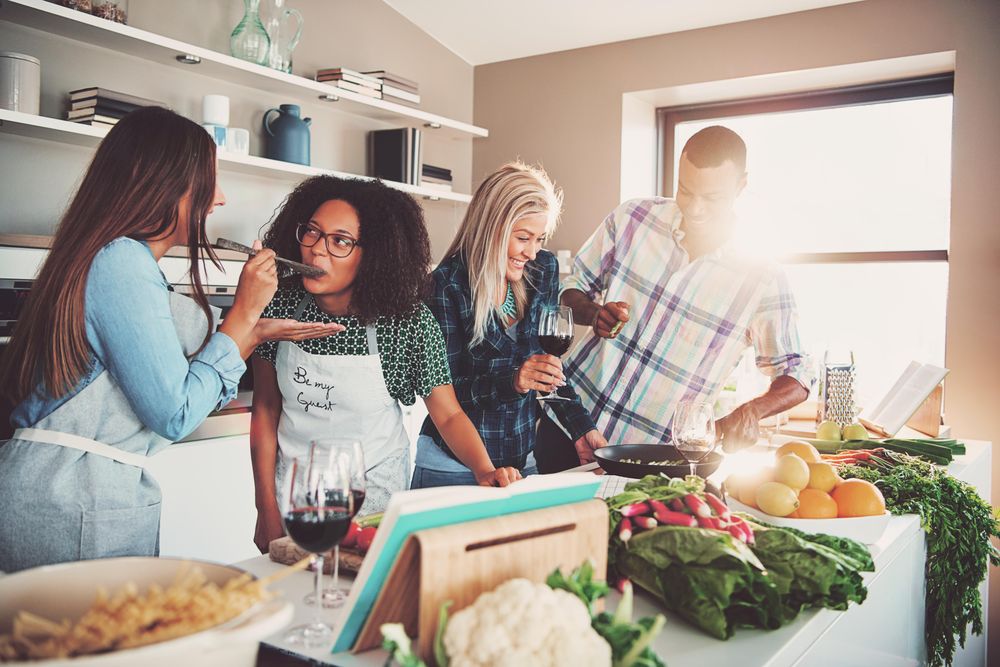 Friends cooking and taste tasting in the kitchen