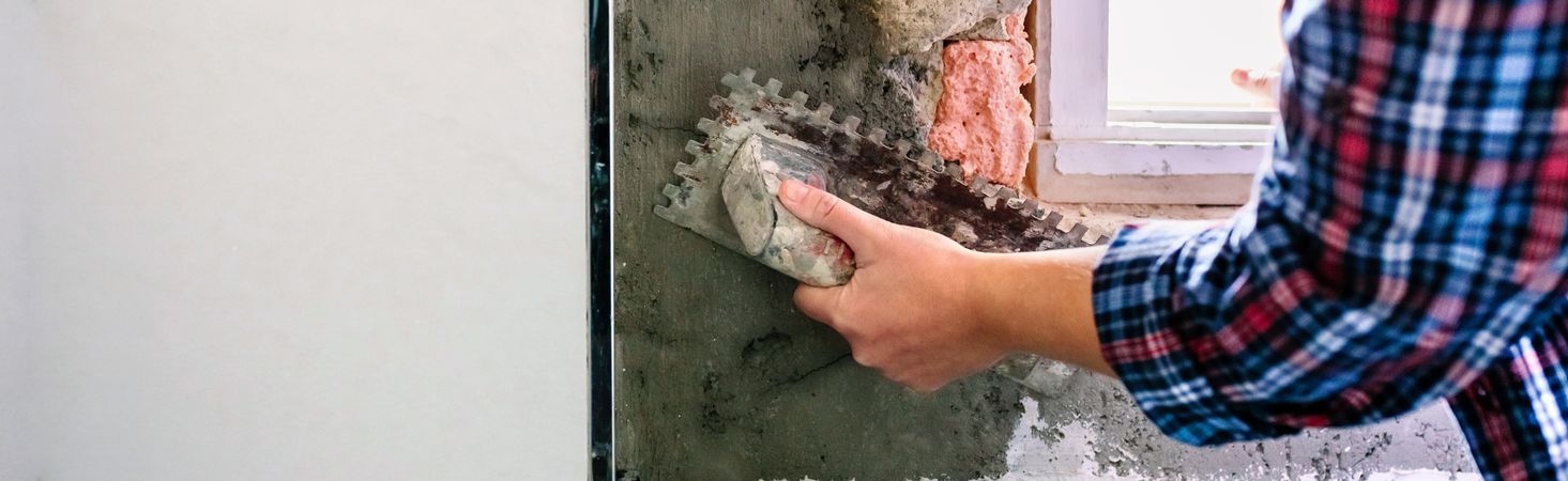 Female bricklayer leveling cement with a trowel