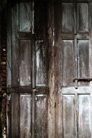 Big old broken wooden door on brick wall of historical building located in Kota Lama, Semarang City, Indonesia.