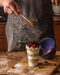 Chef adding honey to granola parfait
