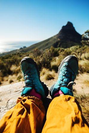 Personal perspective of woman hiker resting on mountain trail