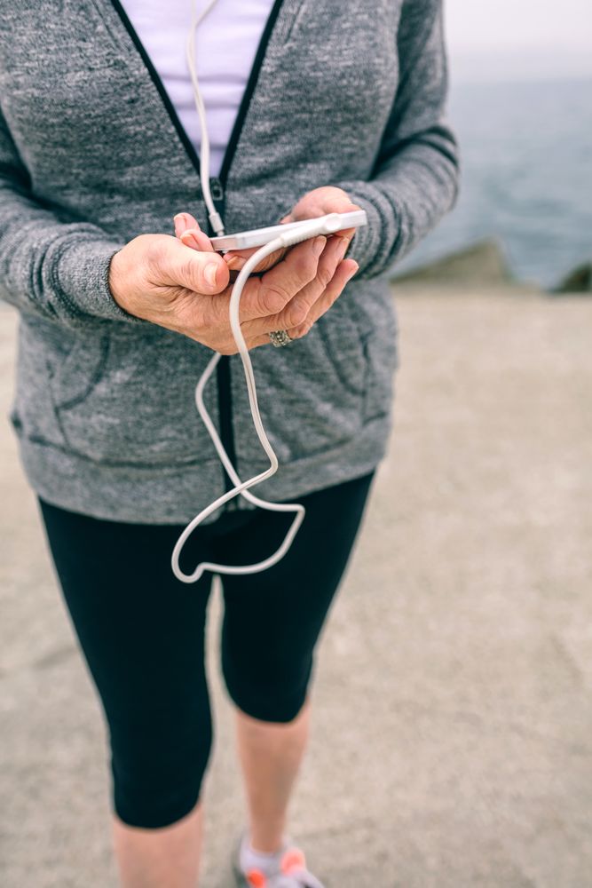 Mature sportswoman holding her smartphone