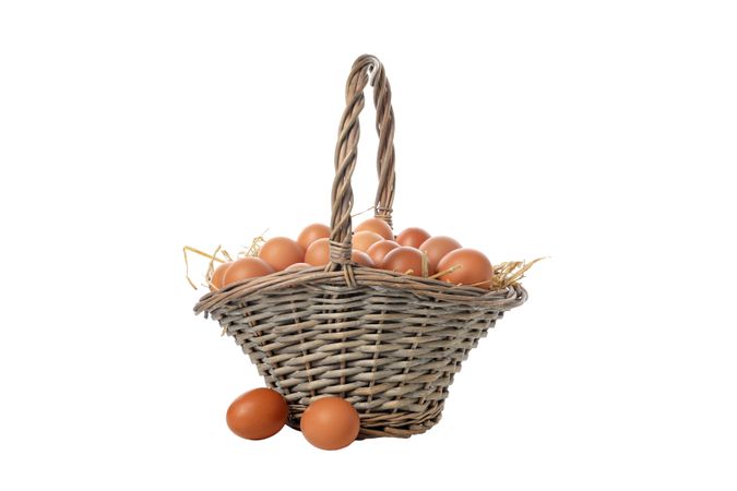 eggs in a wicker basket with handles, isolated on blank background.