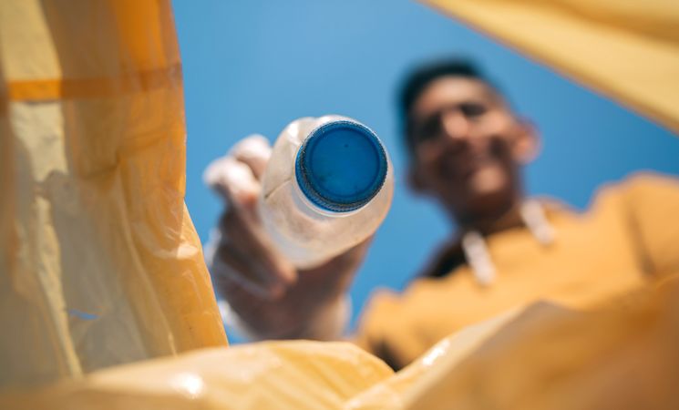 Young man throwing plastic bottles in the trash
