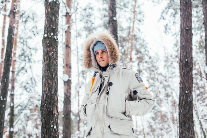 Man in parka outside while it’s snowing