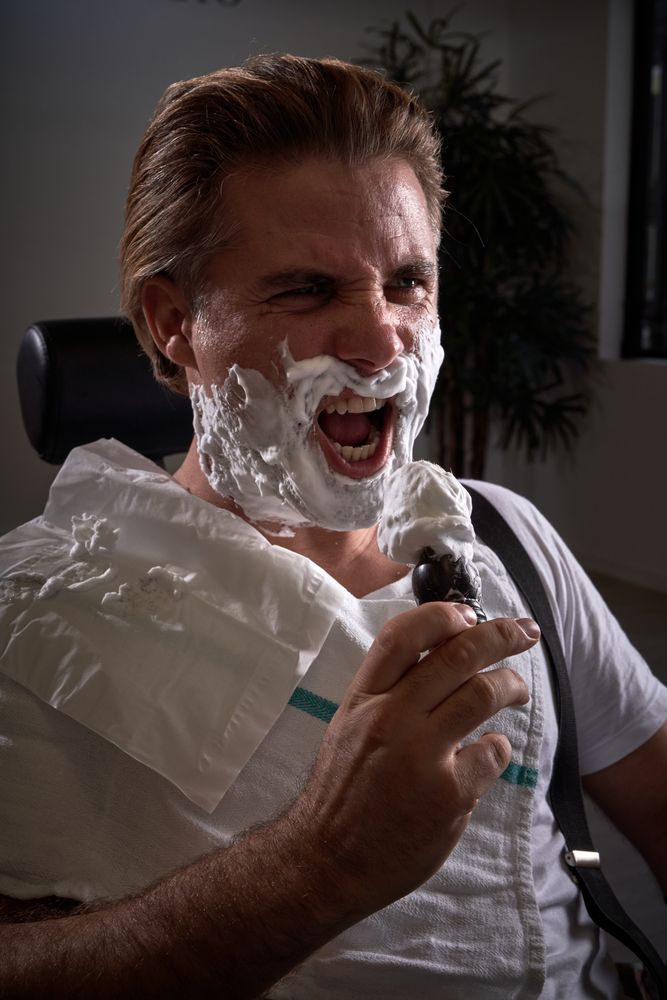 Man with foamy beard pretending to sing