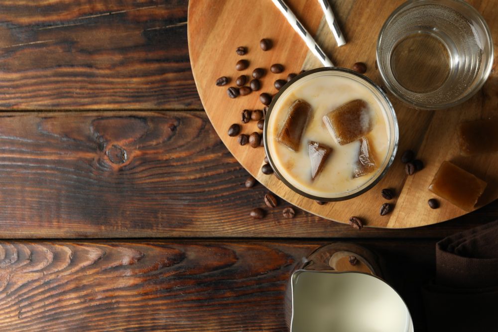 Composition with ice coffee on wooden background, top view