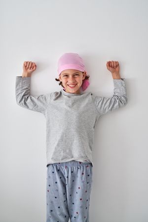 Happy boy smiling and showing biceps during rehabilitation