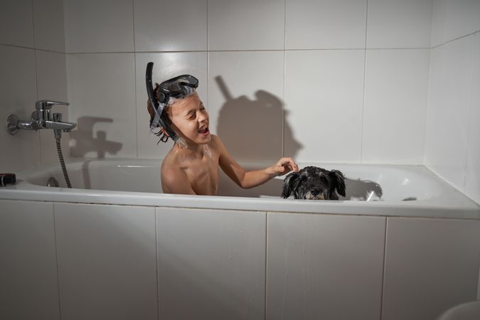 Happy boy with dog in tub