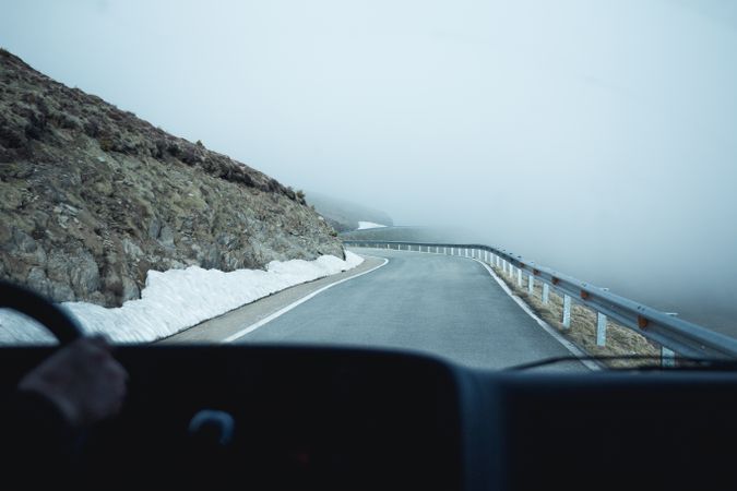 Car riding along road in foggy mountains