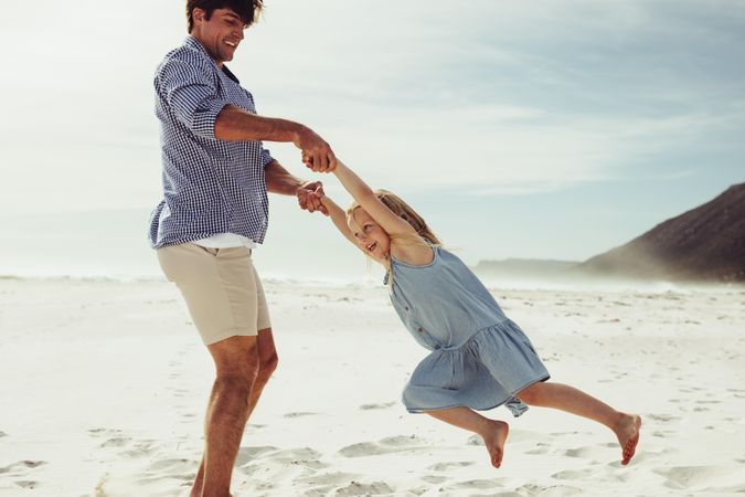 Man playing with his daughter on beach vacation