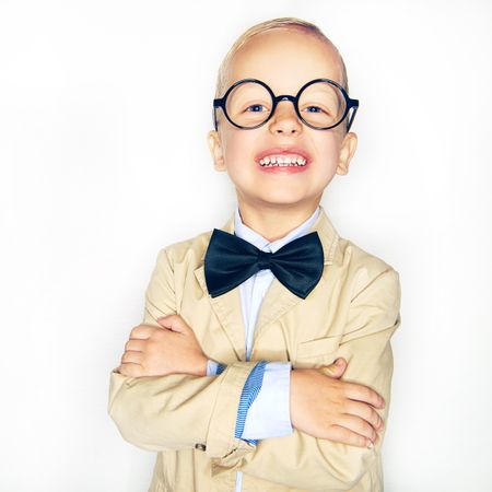 Happy blond boy in glasses and bow tie