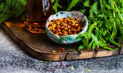 Close up of chili flakes and oil with herbs