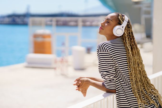 Female relaxing on pier listening to music